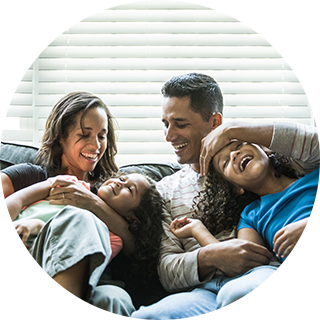 family of four laughing on sofa